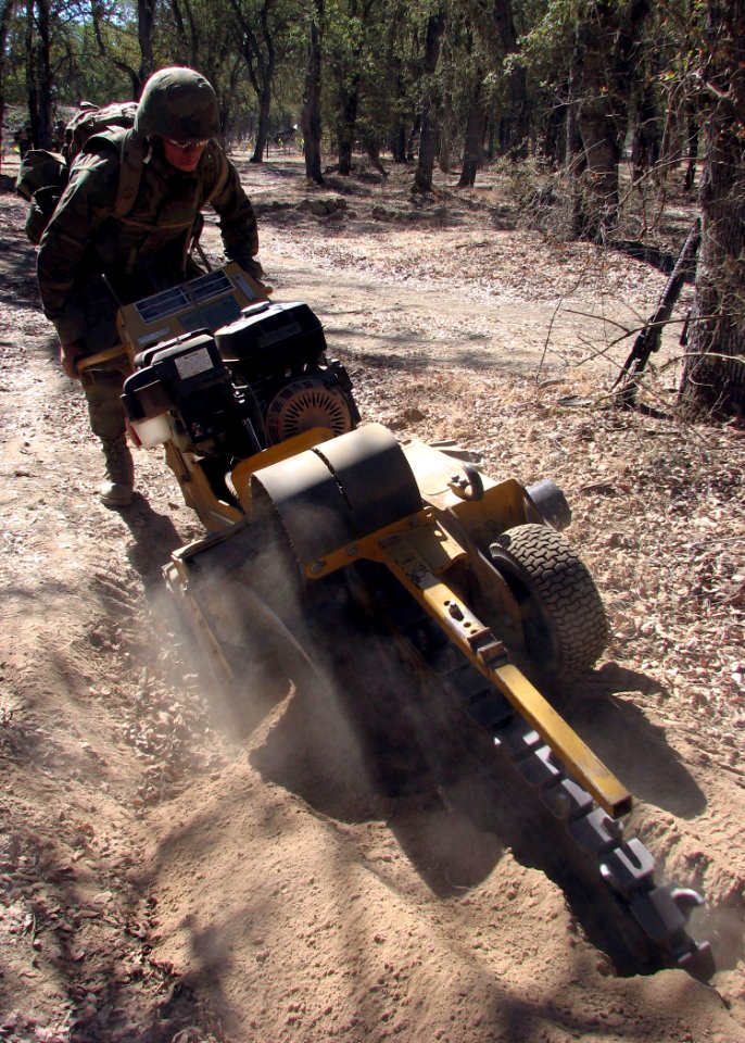 US Navy 070816-N-8547M-031 Construction Electrician Constructionman Daniel J. Nelson uses a trencher to dig a path for underground communications wire during Operation Bearing Duel 6-07