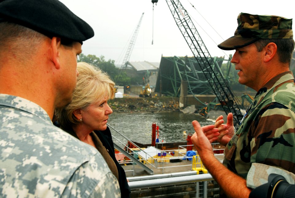 US Navy 070821-N-4515N-048 U.S. Transportation Secretary Mary E. Peters is briefed on Navy recovery efforts while touring the site of the I-35 bridge collapse over the Mississippi River