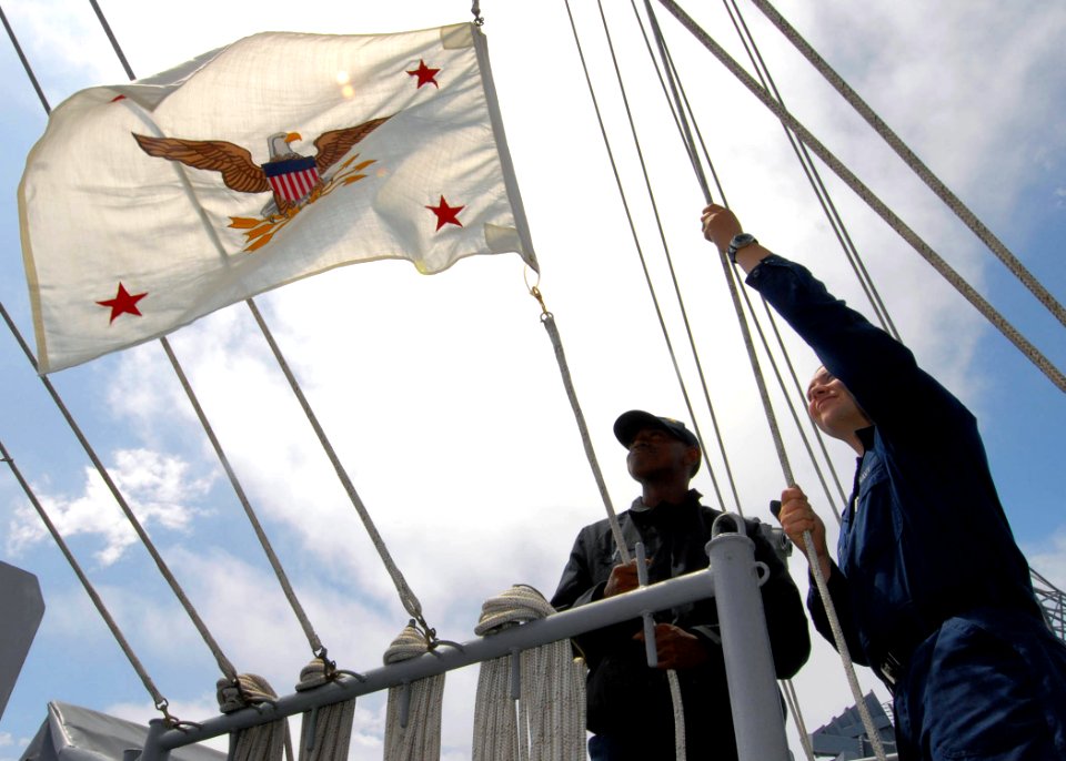 US Navy 070815-N-9898L-005 Quartermaster Seaman Lamont Sports (left) and Quartermaster 3rd Class Richard Nute raise the flag of the General Counsel for the Department of Defense, the Honorable William J. Haynes II