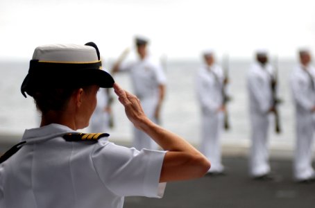US Navy 070819-N-7981E-303 Cmdr. Mindy Suszan, commanding officer of Navy Strike and Air Warfare Center, salutes during a burial at sea for her husband, Lt. Cmdr. Glen Hansen during a ceremony aboard Nimitz-class aircraft carri photo