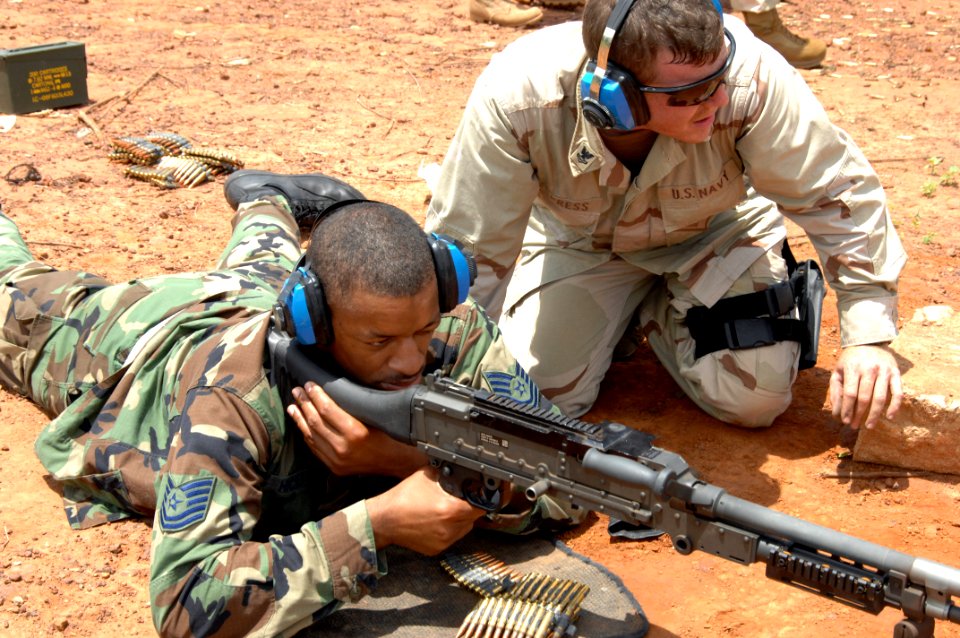 US Navy 070822-F-5735S-036 MM3 instructs Tech. Sgt. Rodney Hicks, of the 4th Combat Camera Squadron, how to use the M-240B