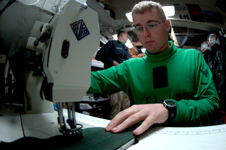 US Navy 070821-N-7883G-013 Aircrew Survival Equipmentman 3rd Class Mark Dorsey, attached to the Golden Dragons of Strike Fighter Squadron (VFA) 192, sews on a foreign object and debris pouch in the paraloft shop