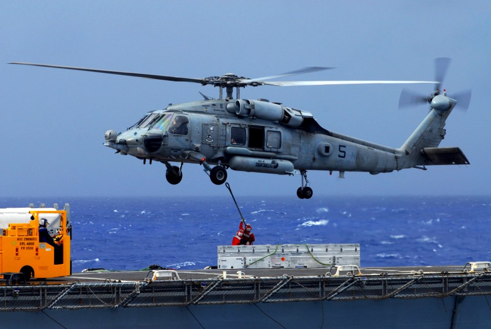 US Navy 070818-N-2659P-131 Sailors aboard Military Sealift Command ammunition ship USNS Flint (T-AE 32) attach a cargo pendant to an HH-60H Seahawk