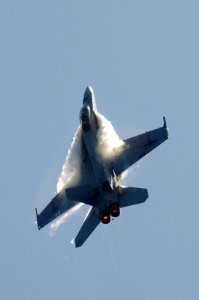 US Navy 070823-N-3136P-040 Water vapor flows over the wings of an F-A-18F Super Hornet, assigned to Strike Fighter Squadron (VFA) 102, as it performs a high-speed pass during an air power demonstration