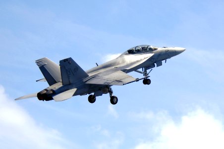 US Navy 070823-N-3136P-149 Water vapor flows over the wings of an F-A-18F Super Hornet, assigned to Strike Fighter Squadron (VFA) 102, as it performs a high-speed pass during an air power demonstration
