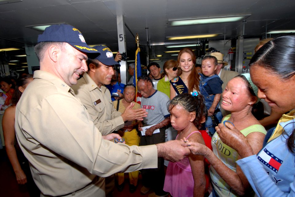 US Navy 070820-N-8704K-067 Capt. Bob Kapcio, mission commander for Military Sealift Command hospital ship USNS Comfort (T-AH 20), gives mission coins to children with genetic skin disorders from the Miss Ecuador Foundation as V