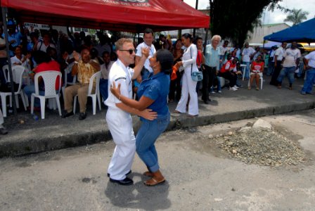 US Navy 070823-N-8704K-045 Musician 3rd Class David Betz, U.S. Navy Showband guitarist attached to the Military Sealift Command hospital ship USNS Comfort (T-AH 20), dances with Maria Valencia during a band performance in downt