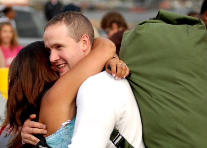 US Navy 070820-N-7981E-212 Fireman Anthony Jaques hugs his wife after his arrival home aboard the Nimitz-class aircraft carrier USS Abraham Lincoln (CVN 72) photo