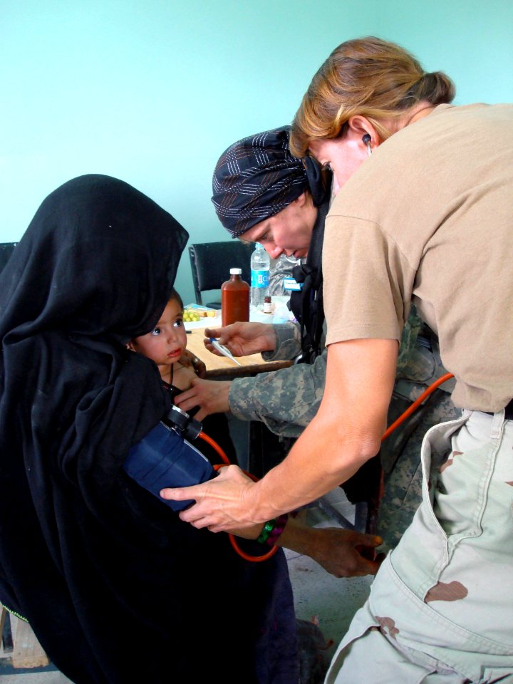 US Navy 070822-F-8346E-002 U.S. Air Force Maj. Debra Roberts, center, and U.S. Navy Lt. Karen Nordine check vital signs on an Afghan woman and her child during a village medical outreach in Shinkay District