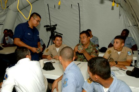 US Navy 070821-N-0989H-020 Machinery Technician 2nd Class Javier Carpio, from the U.S. Coast Guard International Training Division, discusses the various components of a carburetor with Honduran naval officers, Sailors, and por photo