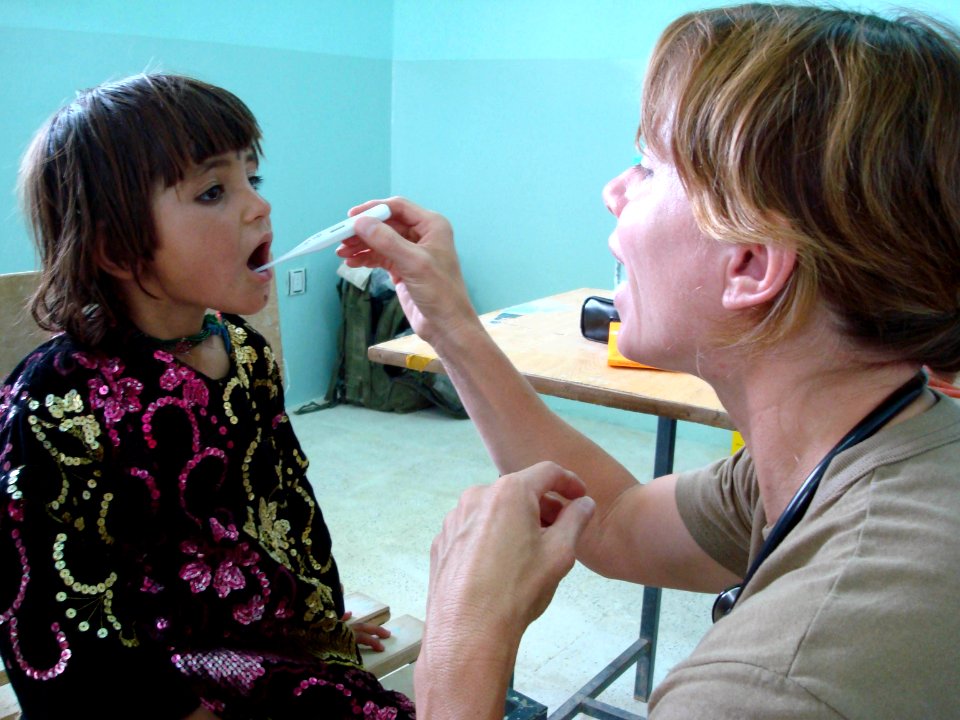US Navy 070822-F-8346E-001 U.S. Navy Lt. Karen Nordine checks the temperature of a young Afghan patient during a village medical outreach in Shinkay District