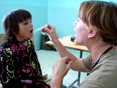 US Navy 070822-F-8346E-001 U.S. Navy Lt. Karen Nordine checks the temperature of a young Afghan patient during a village medical outreach in Shinkay District