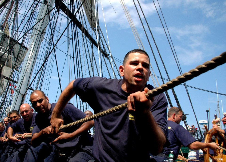US Navy 070824-N-2893B-003 Chief petty officer (CPO) selectees heave around on the halyard to raise USS Constitution's mizzenmast topsail yard while underway
