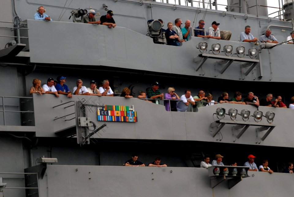 US Navy 070823-N-3541A-131 Sailors and their friends and family members look skyward from the island of Nimitz-class aircraft carrier USS John C. Stennis (CVN 74) as a jet passes overhead during an air power demonstration