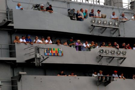 US Navy 070823-N-3541A-131 Sailors and their friends and family members look skyward from the island of Nimitz-class aircraft carrier USS John C. Stennis (CVN 74) as a jet passes overhead during an air power demonstration