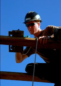 US Navy 070822-N-4267W-004 Steelworker 3rd Class Ben Hickok, assigned to Naval Mobile Construction Battalion (NMCB) 7, uses a circular saw to trim the frame of a roof for a new medical clinic