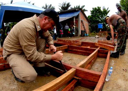 US Navy 070824-N-6278K-165 Lt. Jason Mangum, U.S. Public Health Service industrial hygienist attached to Military Sealift Command hospital ship USNS Comfort (T-AH 20), helps Seabees construct a medical clinic for local villager
