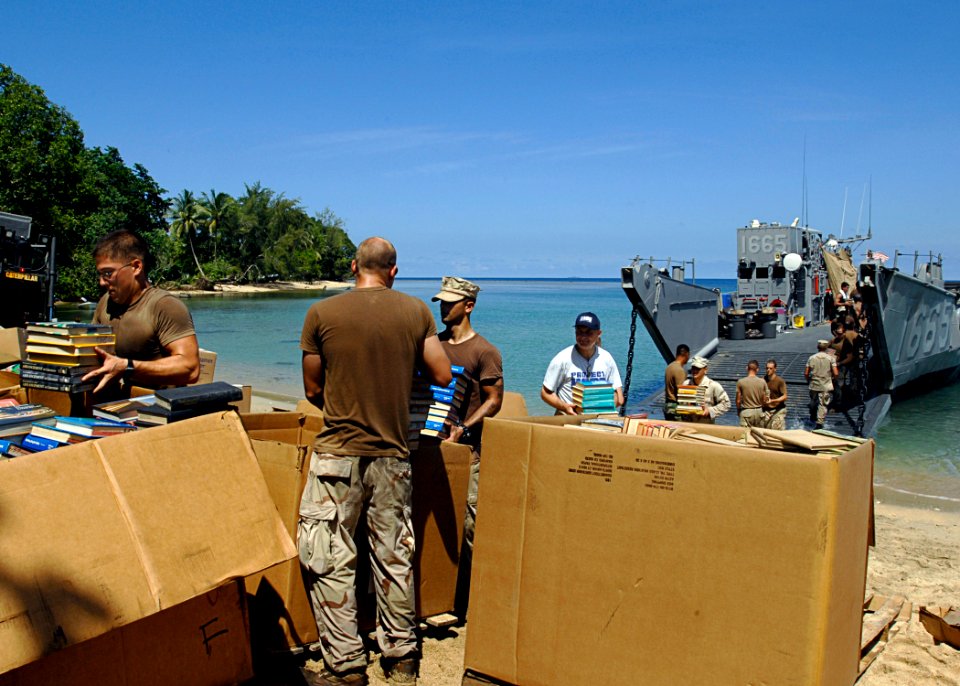 US Navy 070823-N-4954I-117 Seabees attached to Amphibious Construction Battalion (ACB) 1, unload Project Handclasp supplies from Landing Craft Unit (LCU) 1665