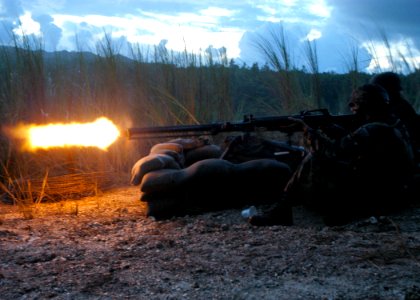 US Navy 070822-F-8678B-105 Builder Constructionman Apprentice Jonathan Dibiasi lights up the night sky with the M2 .50-caliber machine gun while Steelworker Constructionman Apprentice Steven A. Amador provides cover with his M1