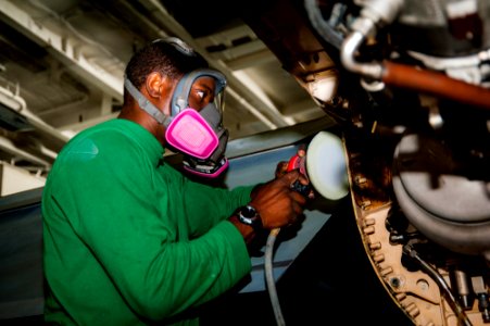USS Carl Vinson Sailor sands an F-A-18F Super Hornet 141024-N-WD464-074