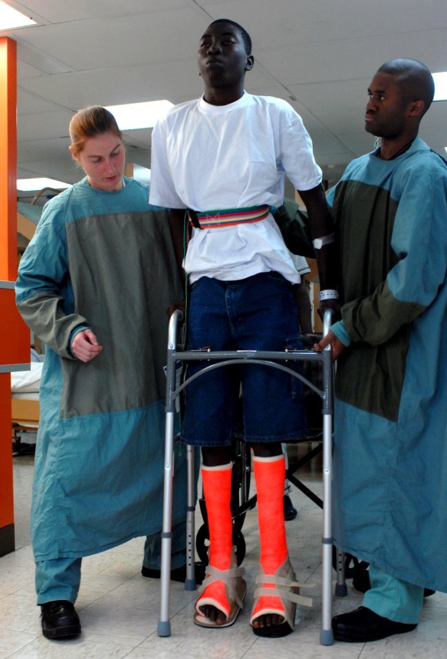 US Navy 070826-N-0194K-016 t. Gwen Smith, left, and Tech. Sgt. William Jones assist Luis Cortez after his surgery