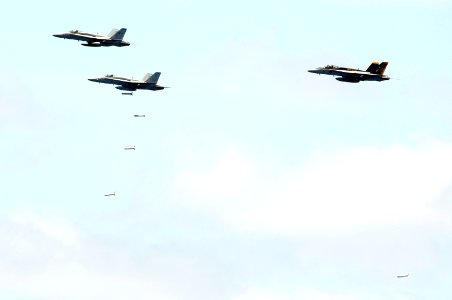 US Navy 070823-N-3136P-048 Two F-A-18C Hornets, assigned to Strike Fighter Squadron (VFA) 192 and VFA-195, and an F-A-18E Super Hornet, assigned to VFA-27, drop general-purpose bombs during an air power demonstration