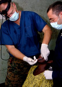 US Navy 070823-N-9195K-035 Lt. Cmdr. Jay Geistkemper, assisted by a volunteer from the San Diego Pre-Dental Society, gives a local woman an anesthetic before performing a tooth extraction during a dental civic action program