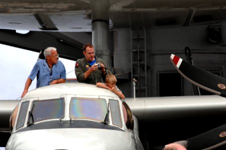 US Navy 070823-N-3729H-047 Lt. Travis Gill watches an air power demonstration with his family members through the top of an E-2C Hawkeye on the flight deck of Nimitz-class aircraft carrier USS John C. Stennis (CVN 74)