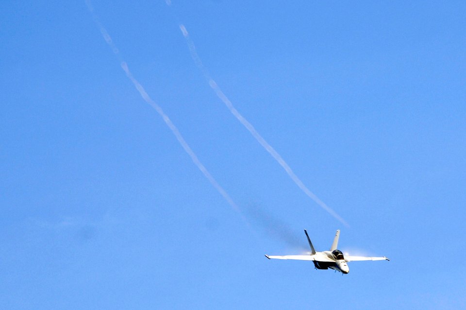 US Navy 070823-N-3136P-023 Water vapor flows over the wings of an F-A-18F Super Hornet, assigned to Strike Fighter Squadron (VFA) 102, as it performs a high-speed pass