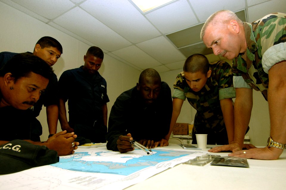 US Navy 070827-N-0989H-007 Off the coast of Belize City, Senior Chief Master-at-Arms Marc Owins and Master-at-Arms 3rd Class Sigredo Santiago, from the Expeditionary Training Command, assist members from the Belize National Coa