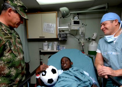 US Navy 070827-N-6278K-116 Gen. Fredy Padilla, commander of Colombian military forces talks with Jhonajaro Montano, a recovering patient in the post-operation section of the operating room on board Military Selift Command hospi