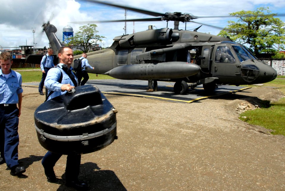 US Navy 070823-N-8704K-007 Musician 1st Class Joe Muzika, attached to Military Sealift Command hospital ship USNS Comfort (T-AH 20), carries his tuba after debarking an Army UH-60 Blackhawk from Joint Task Force Bravo