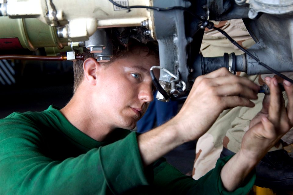 US Navy 070824-N-5387K-015 viation Electrician's Mate 3rd Class Richard Stevenson tightens screws on the main gear box wire harness of an SH-60F Seahawk