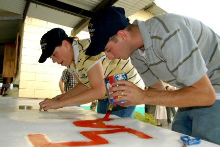 US Navy 070823-N-9486C-075 Mineman 1st Class Ammie Faucett and Electrician's Mate 3rd Class Levi Martin of High Speed Vessel (HSV) 2 Swift paint a sign during a community relations project at the Hogar de Ninos San Ramon orphan