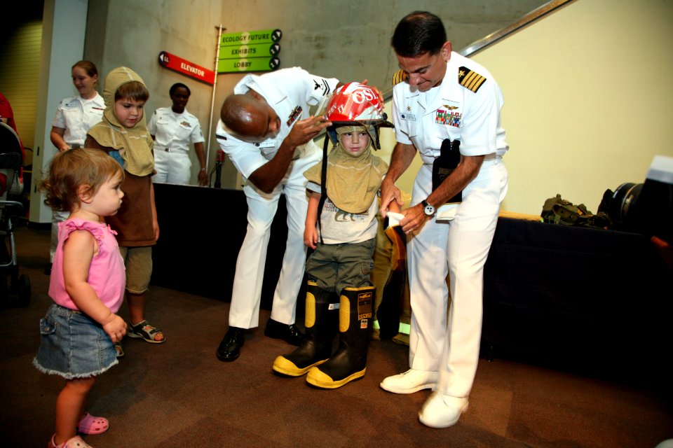 US Navy 070829-N-3271W-003 Capt. Herman Shelanski, commanding officer of USS Harry S. Truman, and Damage Controlman 2nd Class Theodore Wilkerson suit up a young fireman at the St. Louis Science Center
