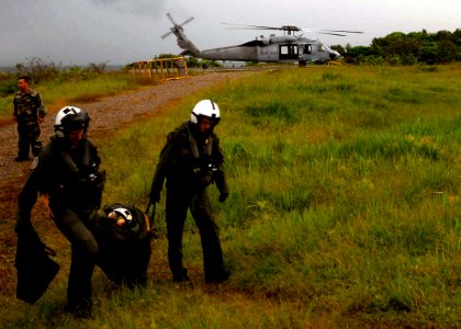 US Navy 070825-N-4238B-268 Sailors attached to the Military Sealift Command hospital ship USNS Comfort (T-AH 20) carry flight safety gear for Comfort crew members transiting to the ship via an MH-60S Seahawk photo