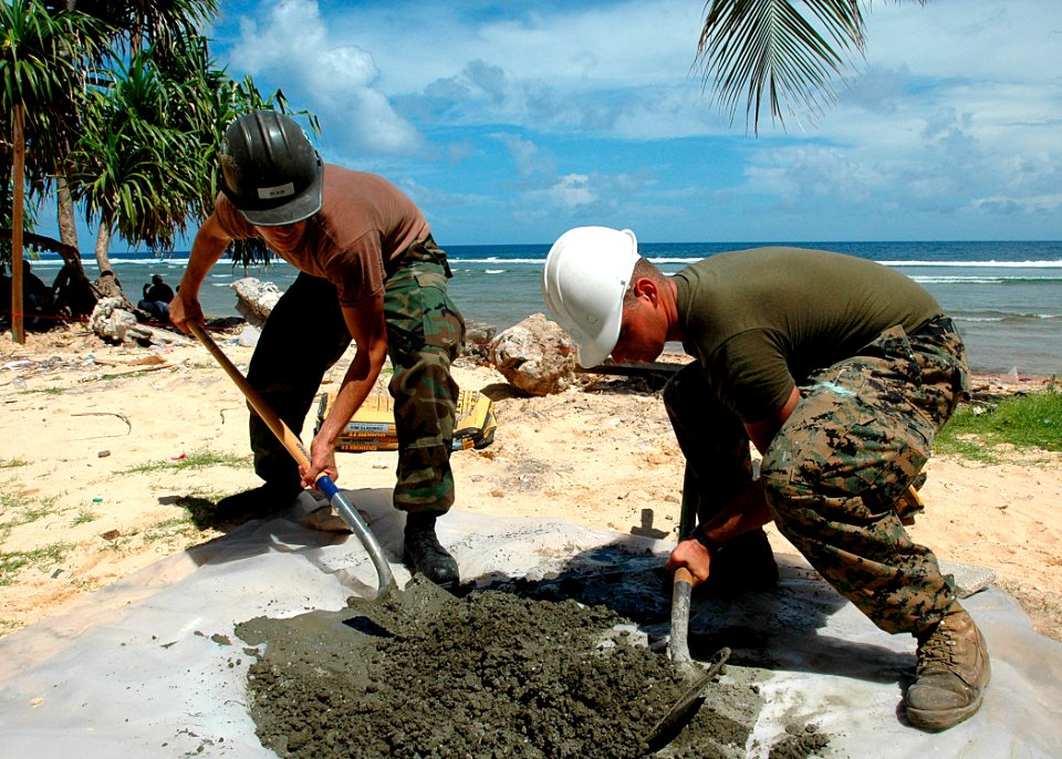 US Navy 070829-N-9421C-084 Construction Mechanic Constructionman Apprentice Matthew Blair and Hospitalman Cody Reedy, from Naval Mobile Construction Battalion (NMCB) 7, mix cement for a fence post during an engineering civic ac