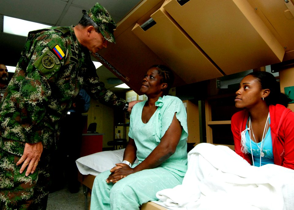 US Navy 070826-N-6278K-150 Gen. Fredy Padilla, commander of Colombian military forces, talks with a patient and her daughter in one of the patient wards on board Military Sealift Command hospital ship USNS Comfort (T-AH 20) dur