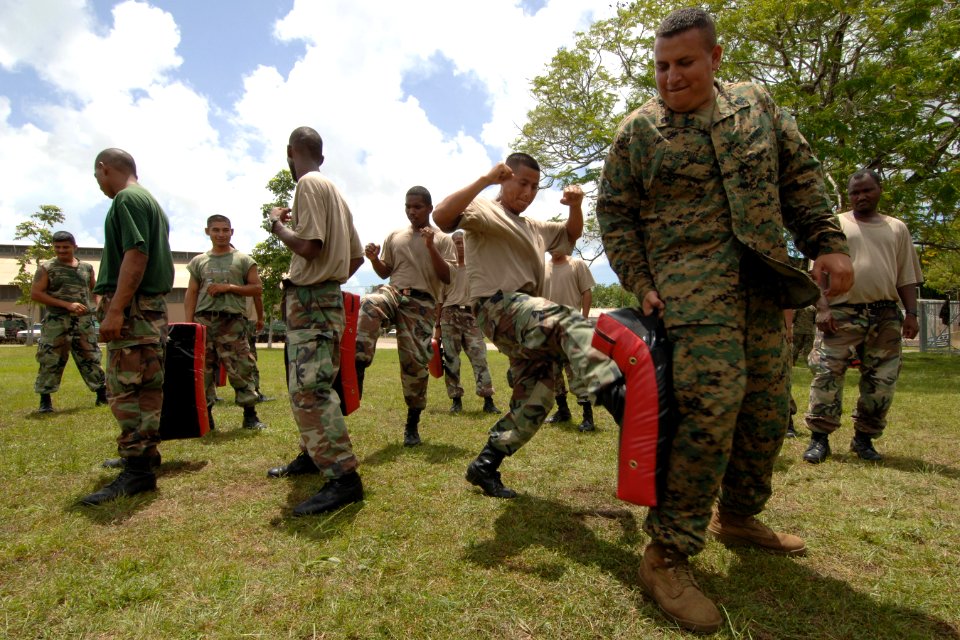 US Navy 070828-N-0989H-027 Marine Corps Staff Sgt. Oscar Cruz, assigned to a U.S. Marine Corps mobile training team, assists recruits of the Belize Defense Force on martial arts pad drills and unarmed manipulations during small