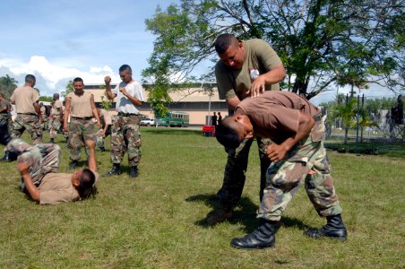 US Navy 070828-N-0989H-192 Marine Corps Staff Sgt. Oscar Cruz, assigned to a U.S. Marine Corps Training Team, assists a member of the Belize Defense Force with executing the proper steps for a controlled fall during small unit