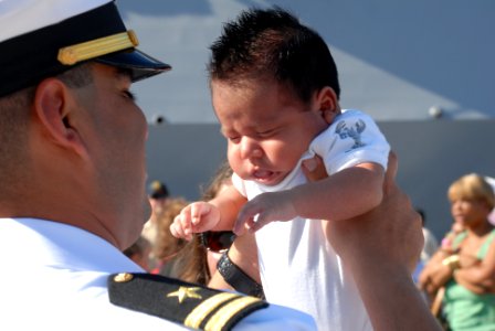 US Navy 070829-N-9909C-005 Lt. Charlie Limon, force protection officer aboard guided-missile destroyer USS Preble (DDG 88), meets his son for the first time after returning from a 7.5-month deployment as part of John C. Stennis
