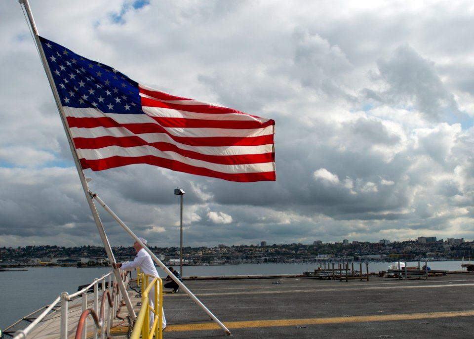 USS Carl Vinson flies the American flag at half-mast. (19915431342)