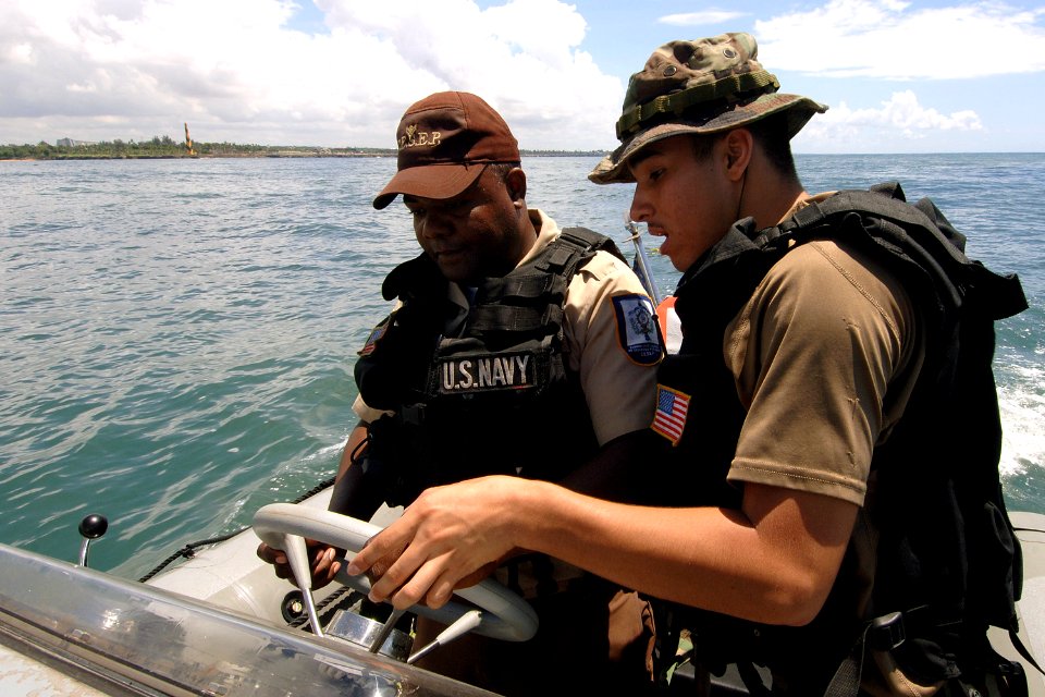 US Navy 070904-N-0989H-028 Master-at-Arms 3rd Class Sigredo Santiago, of U.S. Navy Expeditionary Training Command, trains a Dominican Republic sailor on the operation of a rigid hull inflatable boat