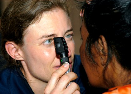 US Navy 070901-N-9195K-045 Cmdr. Elizabeth Satter performs an eye exam on a local woman during a medical civic action program held at Delap High School