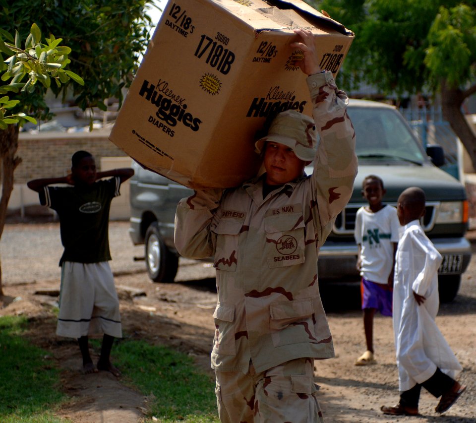 US Navy 070901-N-1003P-007 Equipment Operator 3rd Class Robert Shepherd, Naval Mobile Construction Battalion (NMCB) 40, carries a box of supplies into Centre De Sante Communautaire Arnaud medical facility