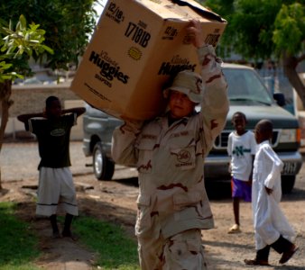 US Navy 070901-N-1003P-007 Equipment Operator 3rd Class Robert Shepherd, Naval Mobile Construction Battalion (NMCB) 40, carries a box of supplies into Centre De Sante Communautaire Arnaud medical facility photo