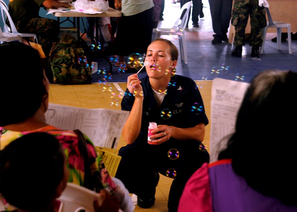 US Navy 070901-N-9195K-040 Aviation Ordnanceman 3rd Class Ashley Cameron blows soap bubbles for local children while assisting with a medical civic action program held at Delap High School