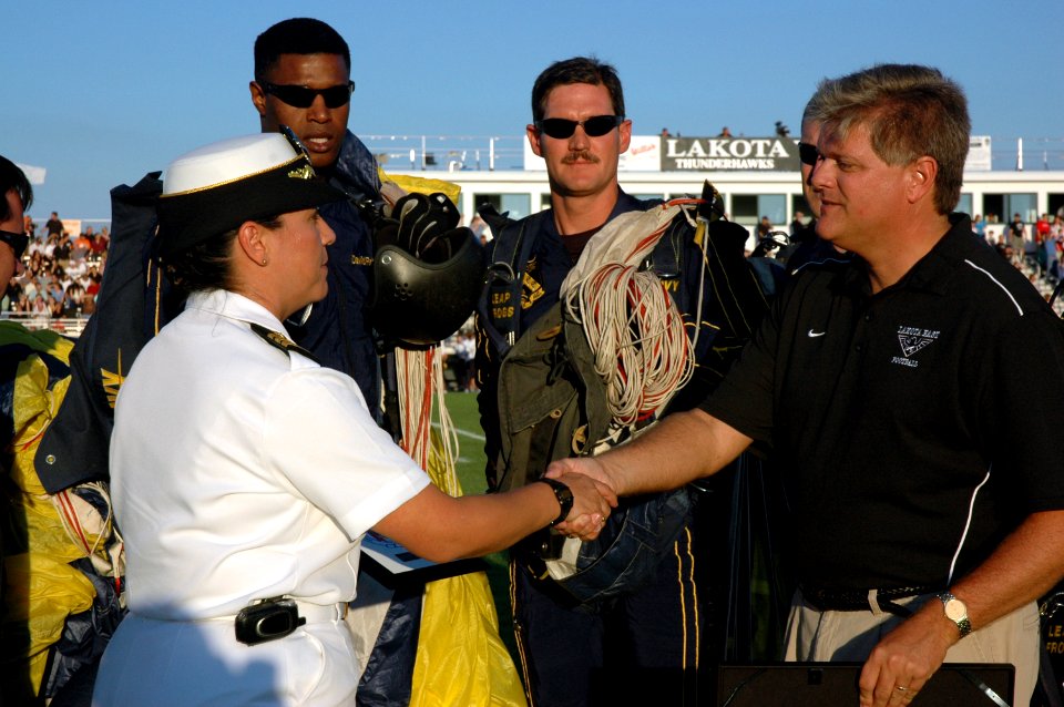 US Navy 070831-N-1805P-005 Navy Recruiting District Ohio executive officer Cmdr. Carol Kushmeir presents a command coin and plaque to Lakota East High School principal Keith Kline moments after the U.S. Navy Parachute Team^sbqu