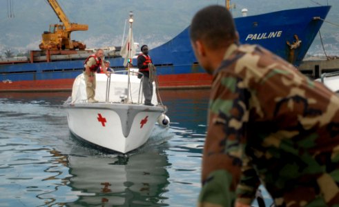 US Navy 070901-N-4238B-432 Builder 1st Class Robert Mendez waits as a hospitality boat from Military Sealift Command hospital ship USNS Comfort (T-AH 20) arrives to pick up crew members who had gone ashore to set up medical sit