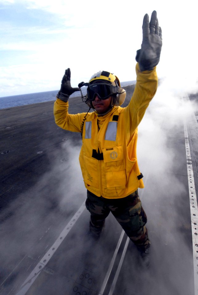 US Navy 070905-N-6326B-044 Aviation Boatswain's Mate (Handling) 3rd Class Rey Lopez directs aircraft aboard nuclear-powered aircraft carrier USS Nimitz (CVN 68)